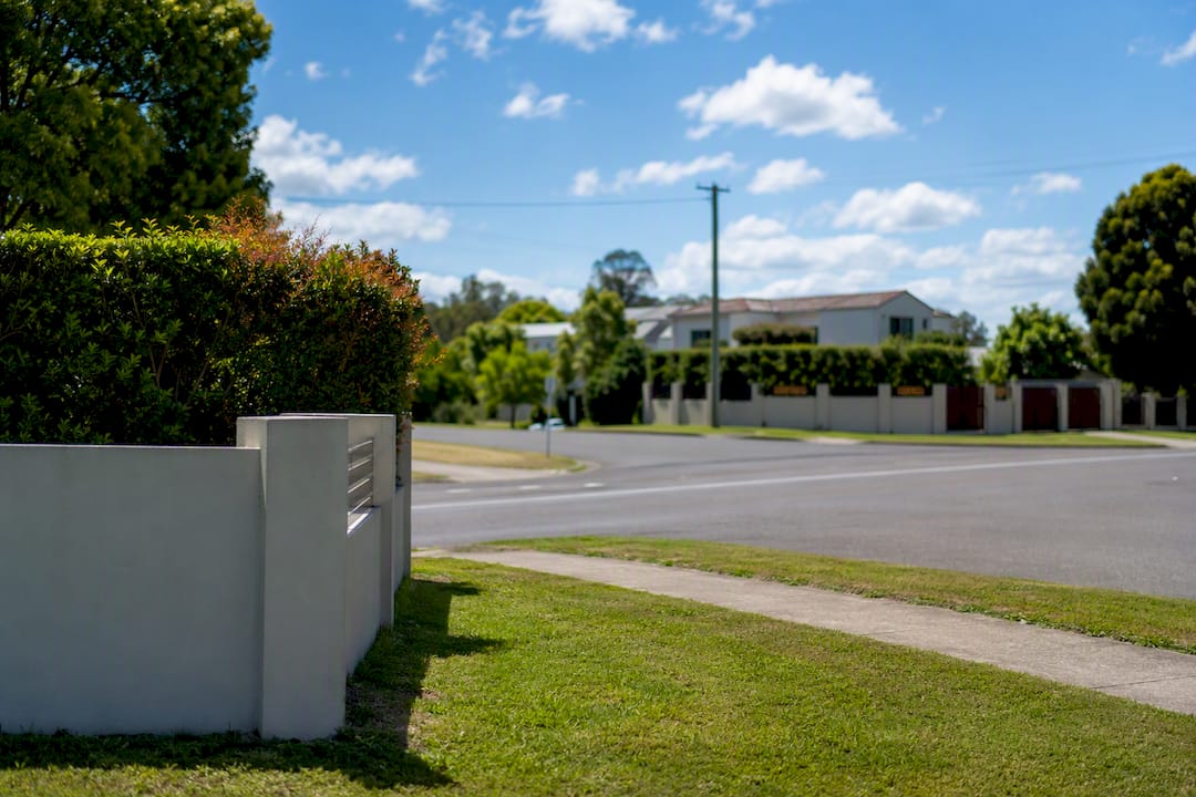Low fence and trimmed shrubs at road intersection