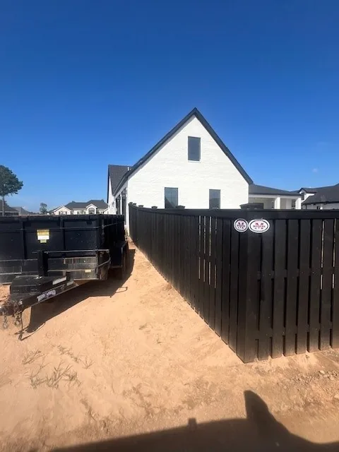 Gate set into a black-stained wood privacy fence