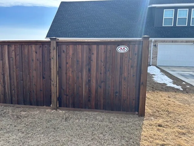 Dark-stained privacy fence with a matching wood gate