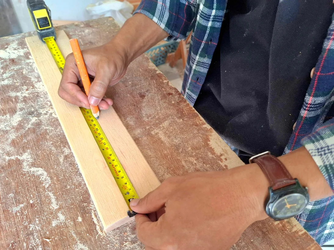 Measuring material in the shop before it is cut