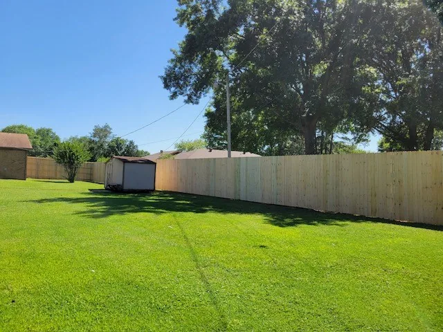 Wood privacy fence bordering an open lawn