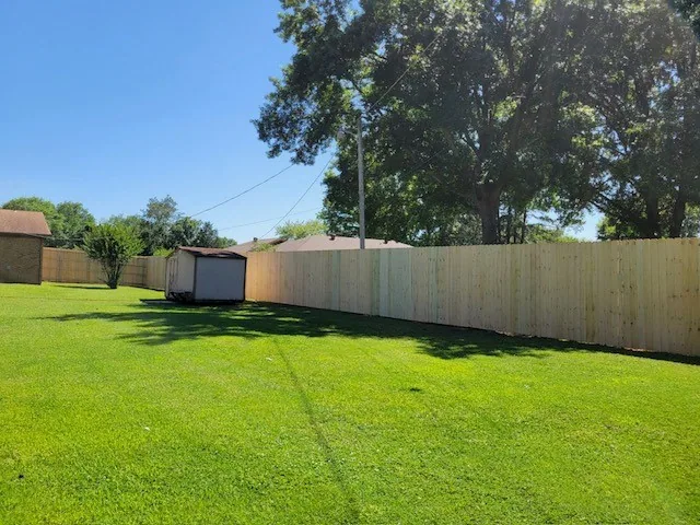 Wood privacy fence running along a residential backyard boundary