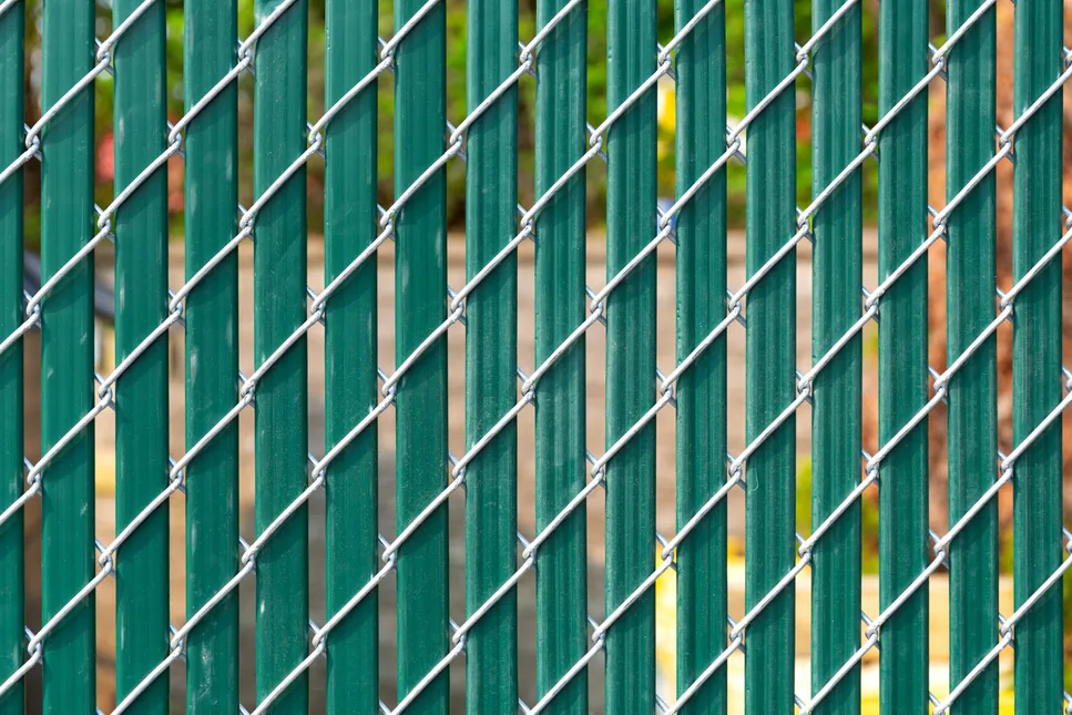 Chain link fence with privacy slats screening a work area