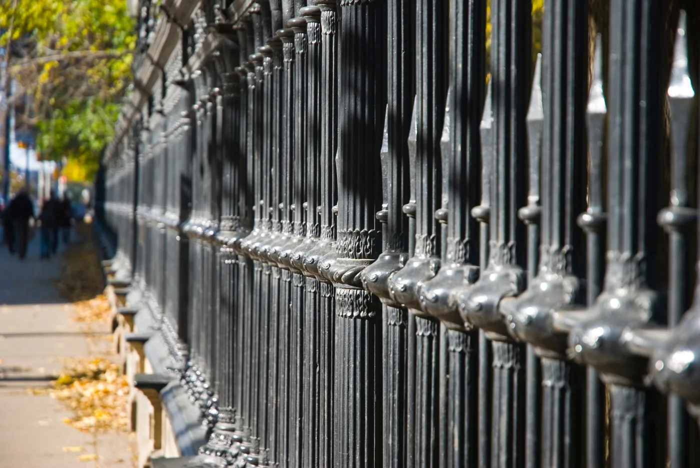 Rows of black ornamental iron fence panels