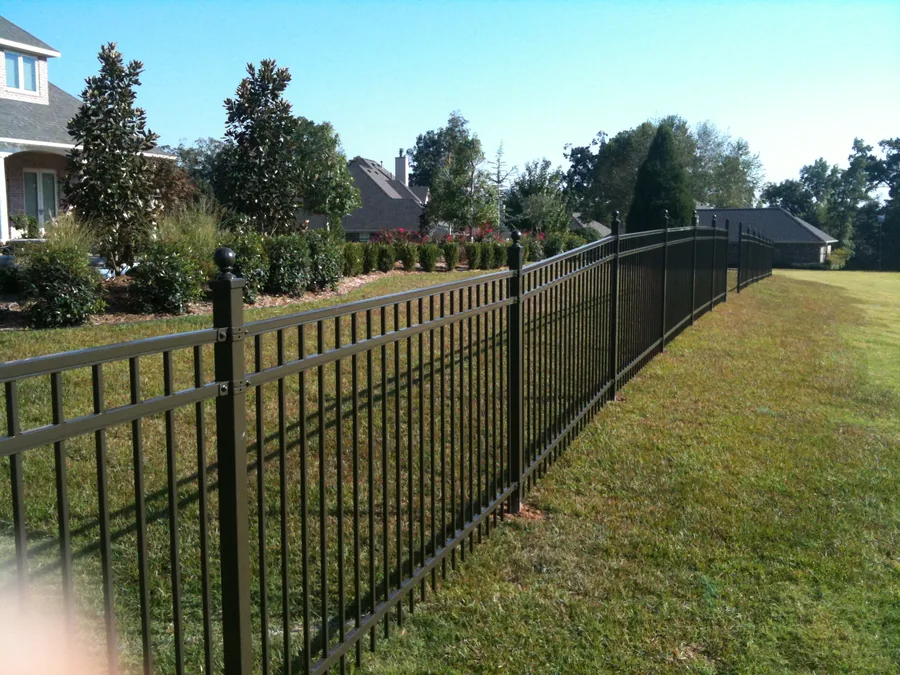 Ornamental iron fence enclosing a landscaped area with a clear view through the pickets