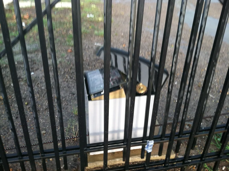 Entry device mounted on the post beside an ornamental gate