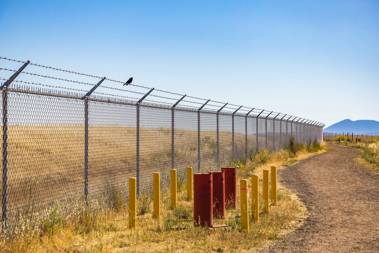 Commercial chain link perimeter with barbed arms