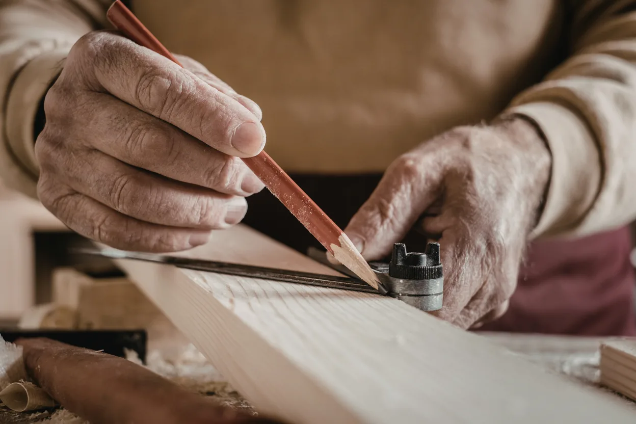Stain being worked into a fence board by hand